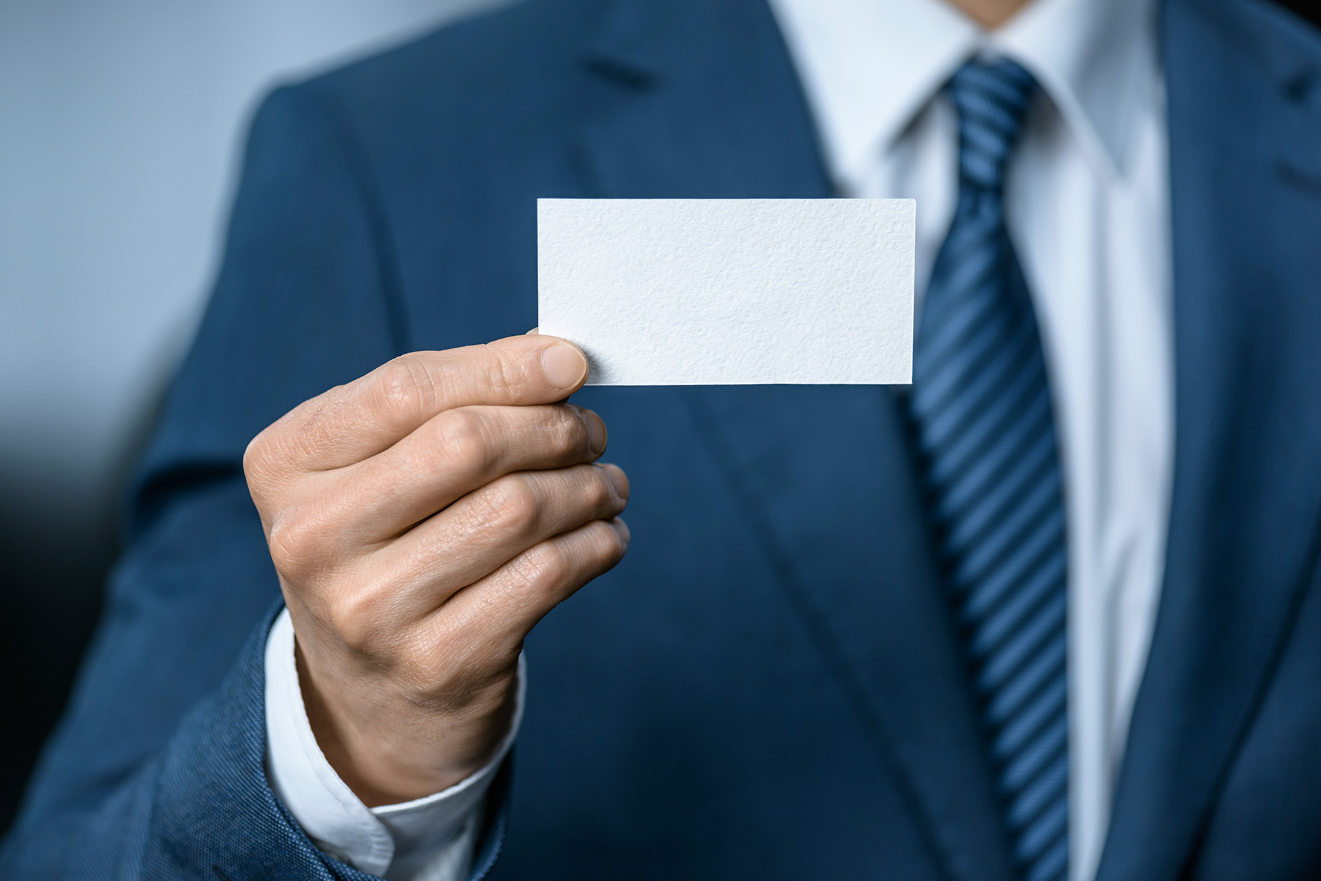Man in business suit presenting blank business card